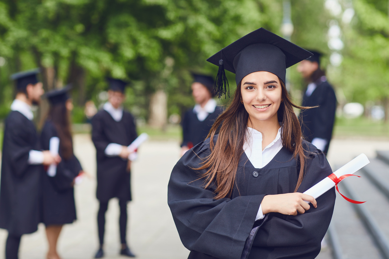 Female Graduate Against Background of Other Graduates